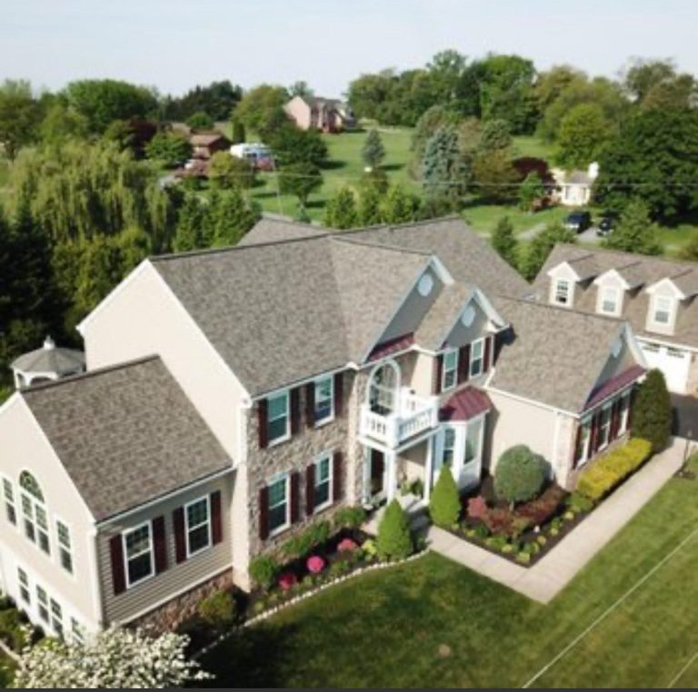 View down onto a large home with a freshly laid shingle roof