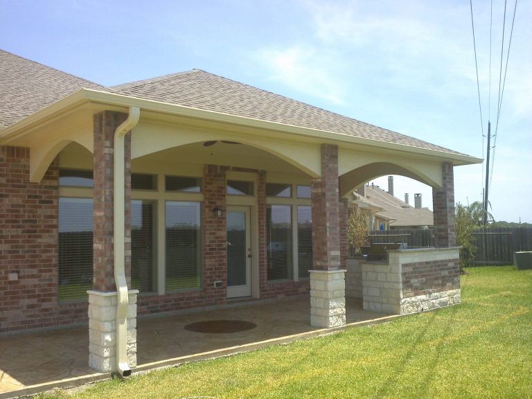 Solid patio cover shading a paved back patio at a Houston house