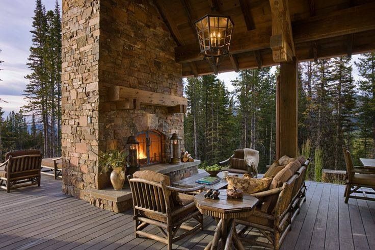 Covered outdoor living space with a stone fireplace and a dining table