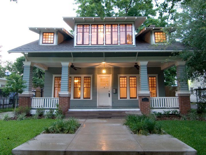 Craftsman porch with new windows lit up in the evening