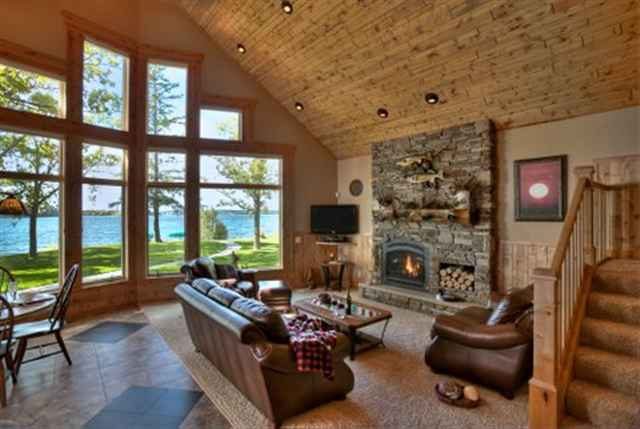 Great room with a tall wall of windows facing a lake