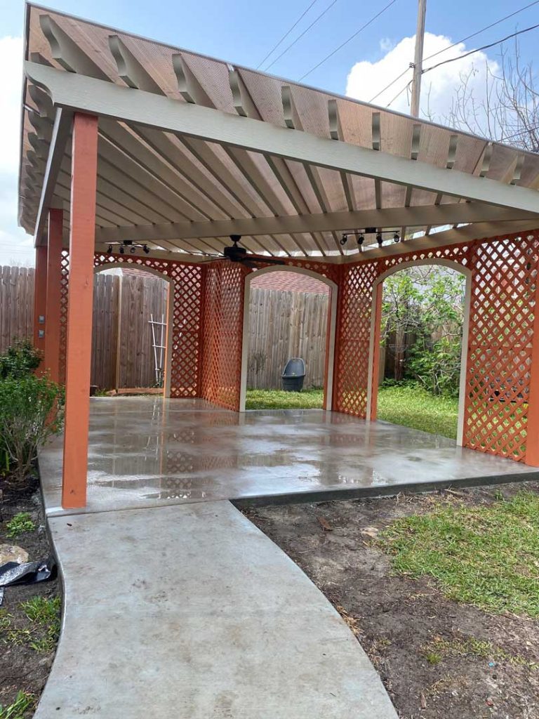 Wood pergola over a paved back patio at a Houston area home