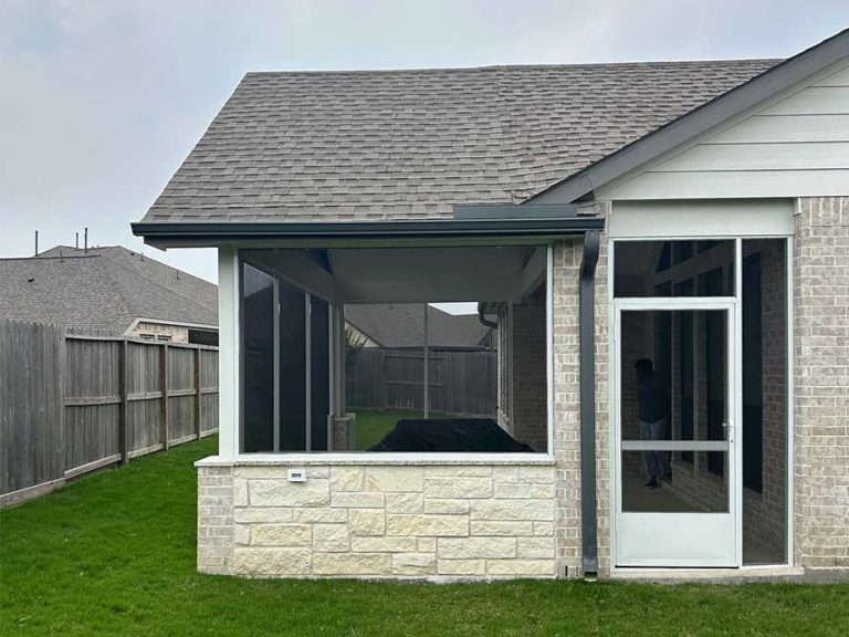 Screened patio with a stone knee wall and a screen door