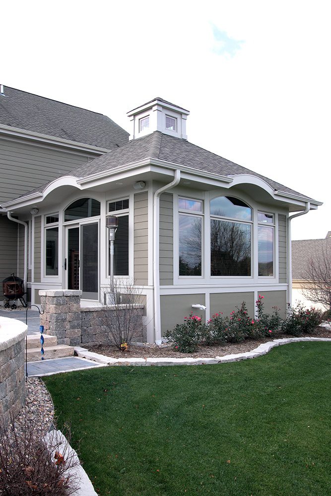 Sunroom addition with a cupola roof on the back of a house