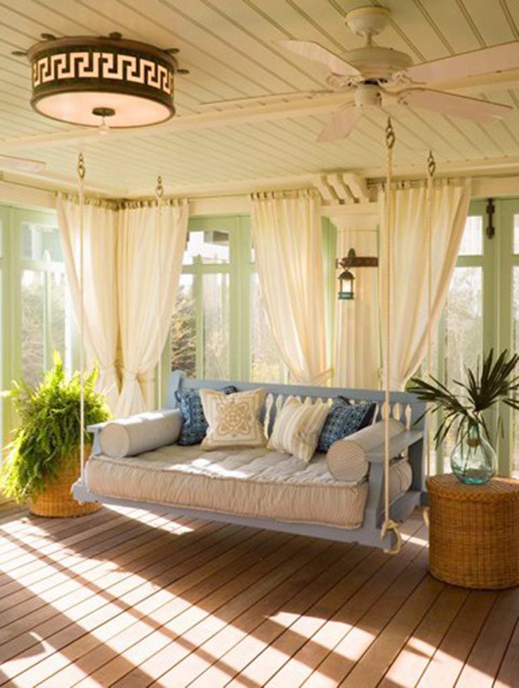 Sunroom with a porch swing, sheer curtains and a ceiling fan
