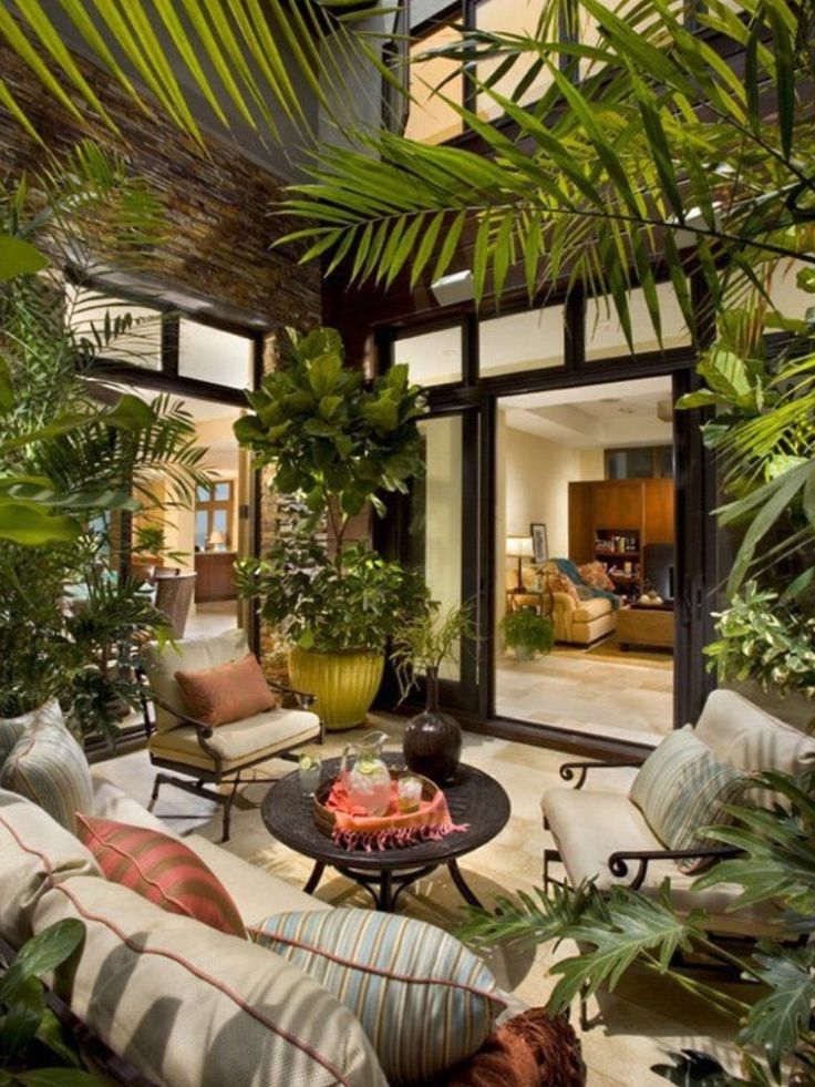 Sunroom filled with tropical plants and patio seating