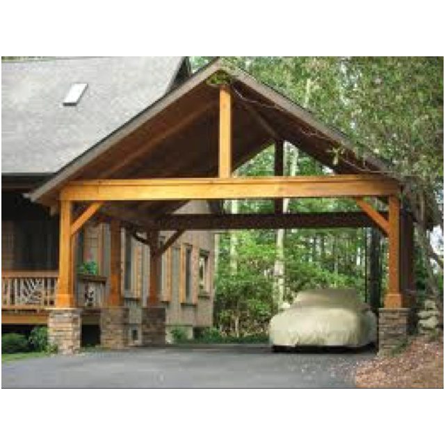Timber framed carport with heavy posts and a gable roof