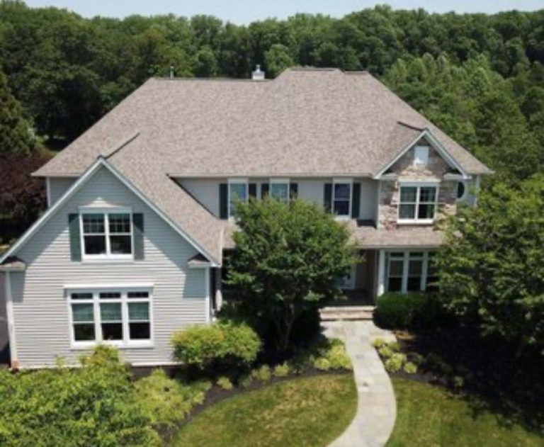 Home with a new shingle roof and a walkway to the front door