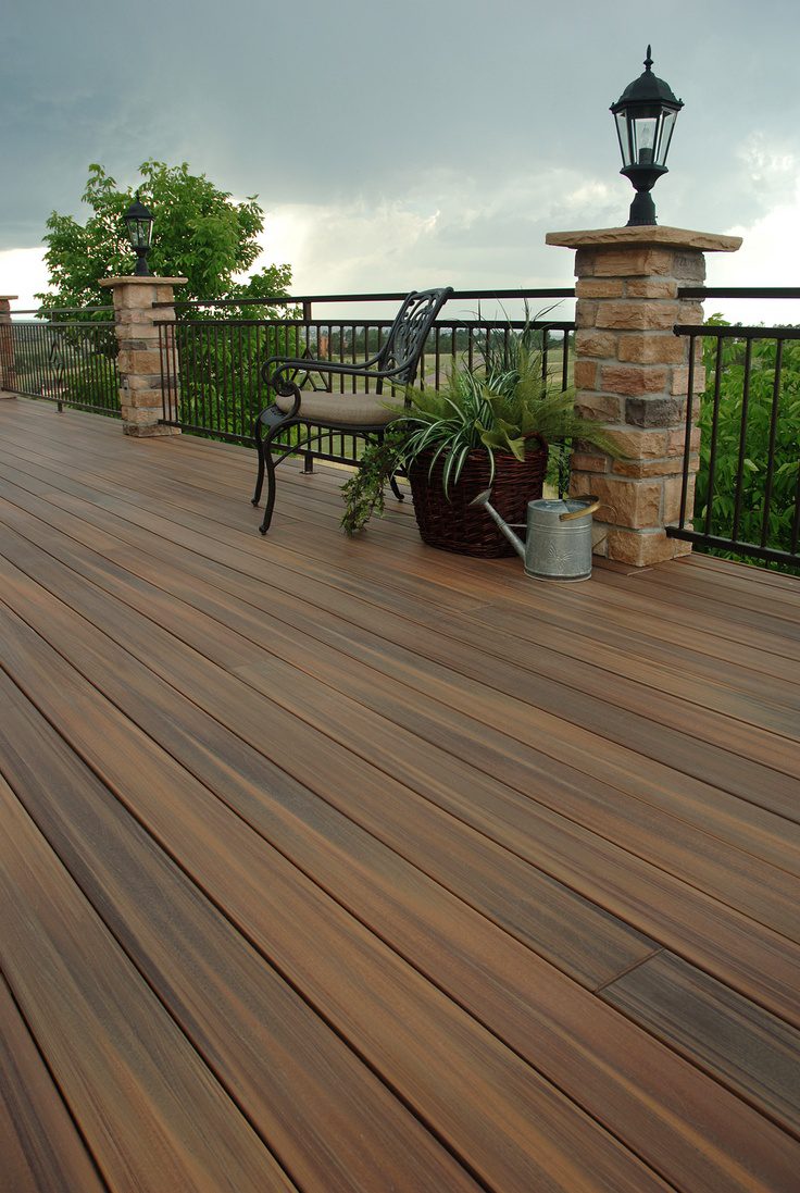 Wood deck with stone pillars, a lamp post and a black metal railing
